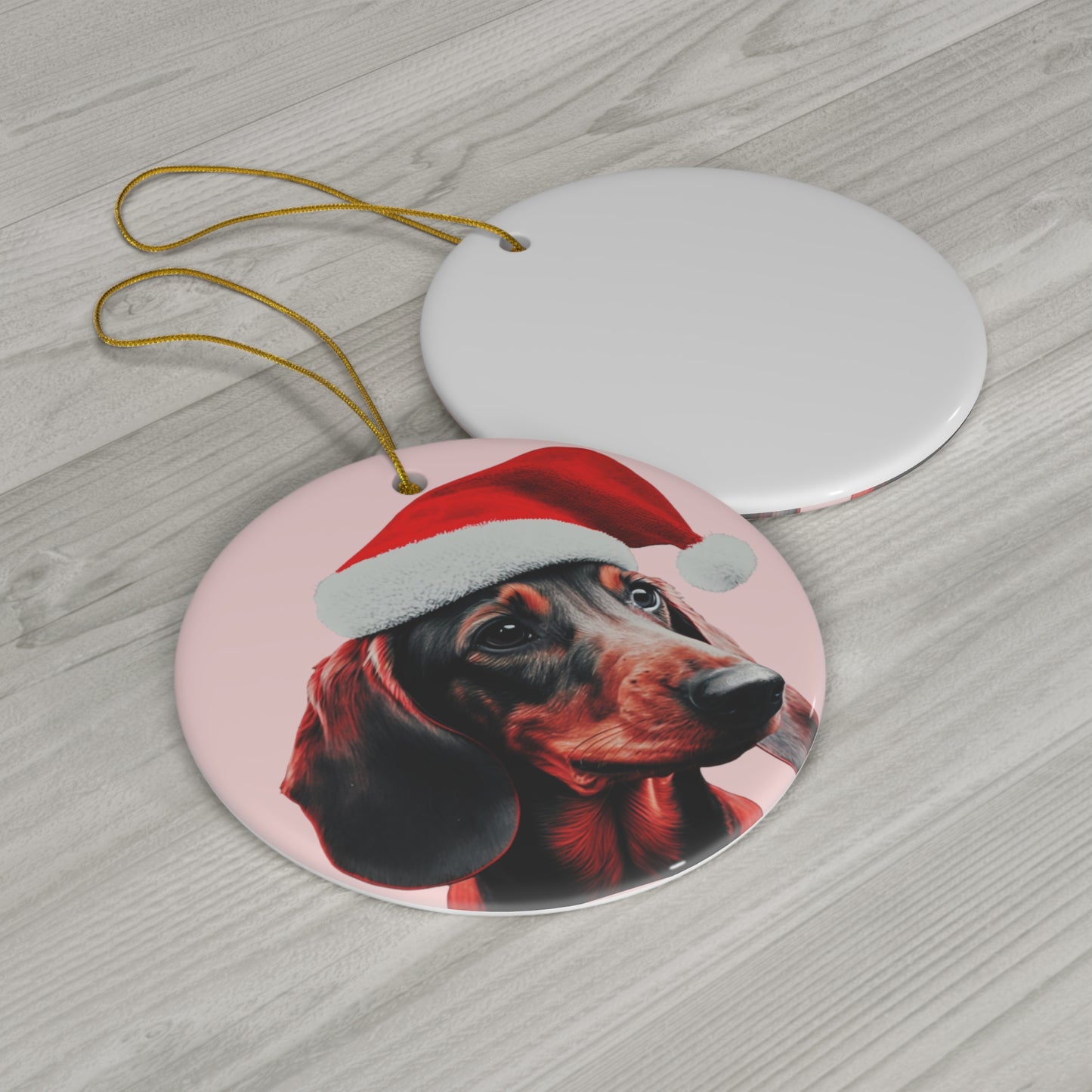A heart or circle-shaped Christmas ornament featuring a cute Dachshund in a Santa hat on a pastel pink background, adding a charming touch to holiday decor