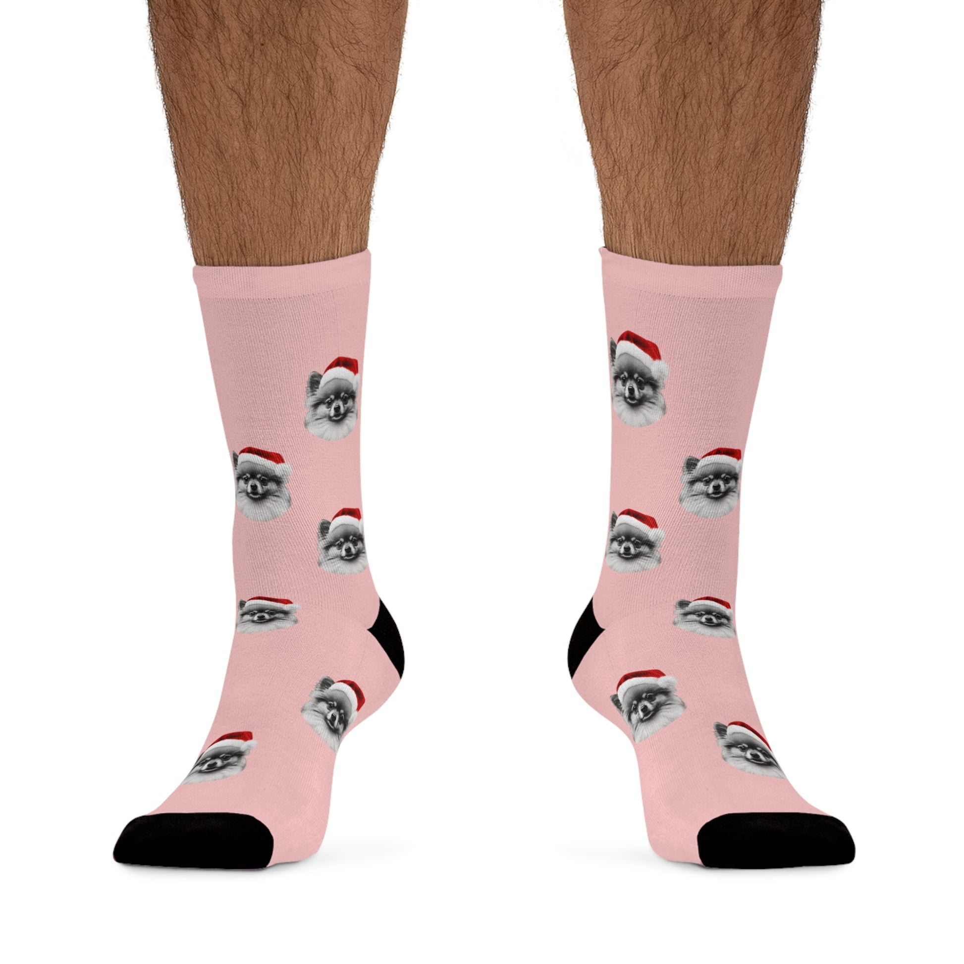 A pair of festive pink novelty socks featuring a Pomeranian wearing a Santa hat