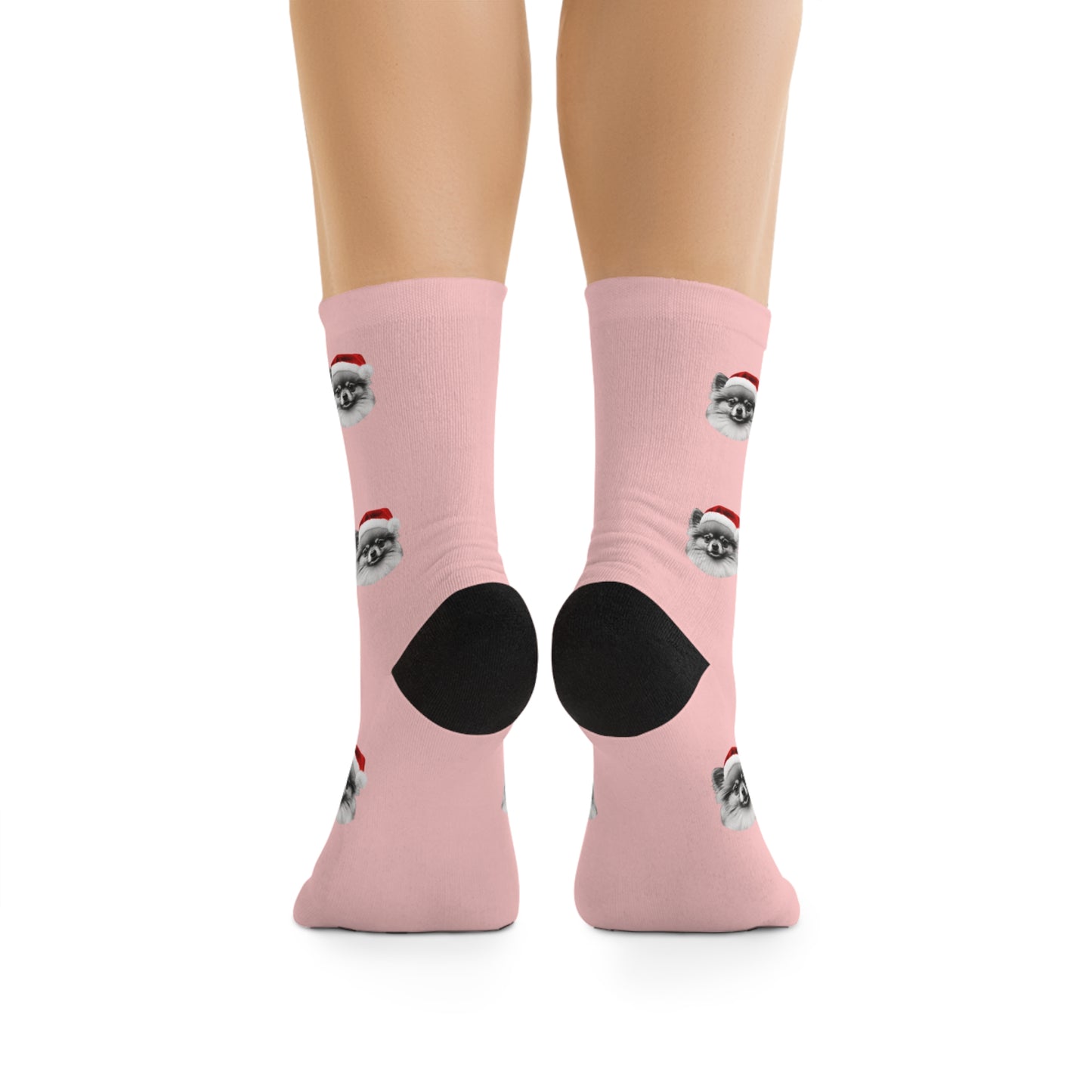 A pair of festive pink novelty socks featuring a Pomeranian wearing a Santa hat